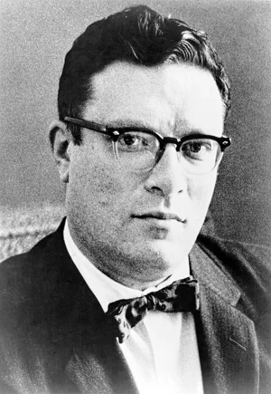 Photograph of man with glasses, dark hair, and pensive look. Wearing a bowtie. Wikimedia Commons.