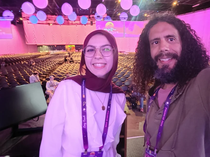 Selfie of man and woman on stage with plenty of seats behind them.
