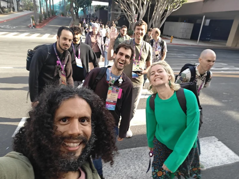 Selfie of man with lots of people following while crossing the street.