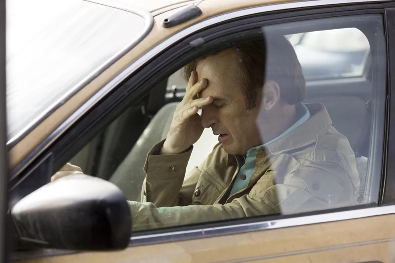 Saul Goodman inside a car facepalming and disappointed.