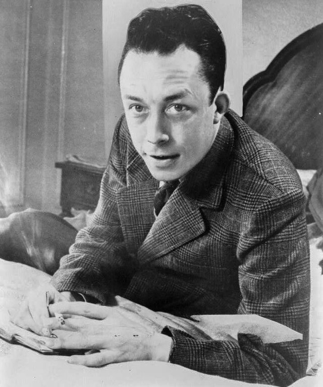 
Albert Camus, gagnant de prix Nobel, portrait en buste, posé au bureau, faisant face à gauche, cigarette de tabagisme.jpg|Albert_Camus,_gagnant_de_prix_Nobel,_portrait_en_buste,_posé_au_bureau,_faisant_face_à_gauche,_cigarette_de_tabagisme 