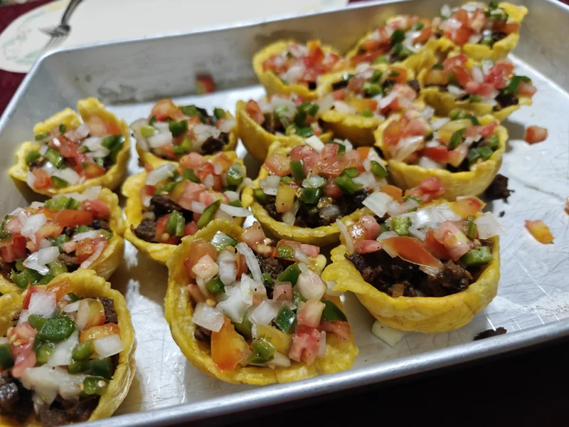 Plantain tostones, made into little baskets with taco meat and pico de gallo inside of them.